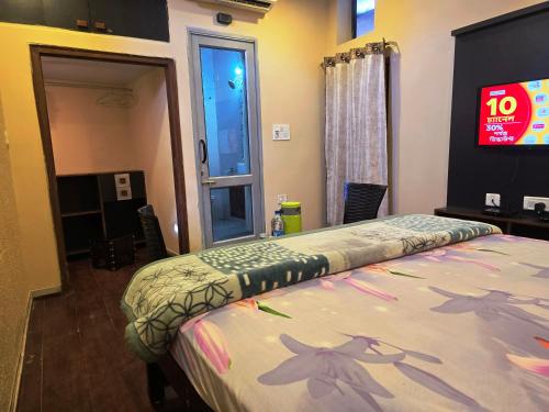 a bedroom with a bed with a tv on the wall at Shaleen Elegance Homestay Near Nakki Lake in Mount Ābu