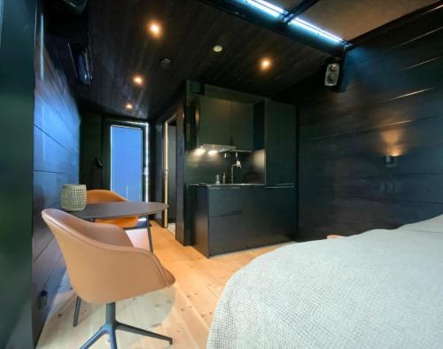 Un dormitorio con una cama y una mesa y una cocina. en Aurora Igloo Village Ylläs Luna Suite, en Ylläsjärvi