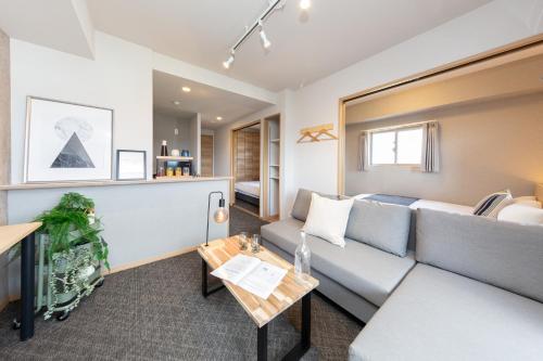 a living room with a couch and a table at レジデンスホテル博多駅南 in Fukuoka