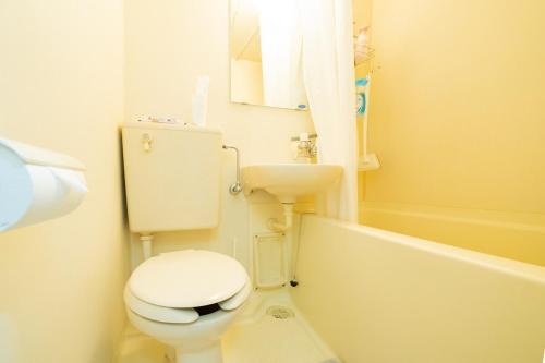 een witte badkamer met een toilet en een wastafel bij Maison de Grue 601 in Sapporo