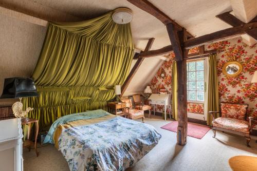a bedroom with a bed and a green curtain at La Closerie du Cassereau in Vernou-sur-Brenne