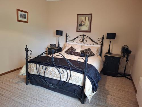 a bedroom with a black bed with two night stands at Cornwall Cottage in Cambridge