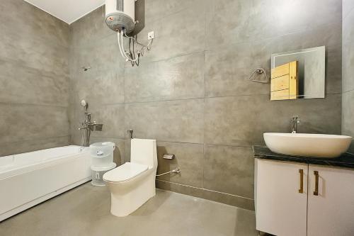 a bathroom with a white toilet and a sink at Hotel Lily Woods, Near JW Marriott Mussoorie - A Beautiful Lavish & Luxury Hotel with Mountain View Managed By Lily in Mussoorie