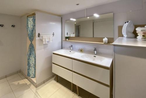 une salle de bain avec deux lavabos et un miroir dans l'établissement Nuits et Jardin, à Nuits-Saint-Georges