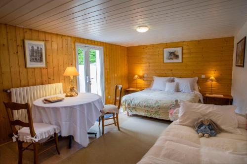 une chambre avec un lit, une table et des chaises dans l'établissement Nuits et Jardin, à Nuits-Saint-Georges