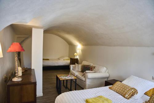 a room with a bed and a couch and a chair at La Villa des Charmilles in Vernoux-en-Vivarais