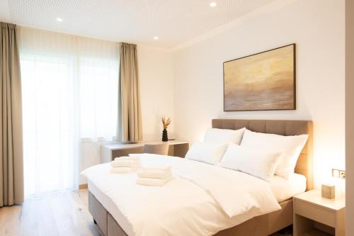 Un dormitorio con una gran cama blanca con almohadas blancas. en Frant Living - Graz Apartments, en Graz
