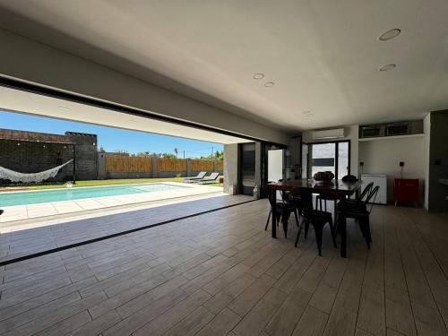 comedor con mesa, sillas y piscina en Funes temporario, en Funes