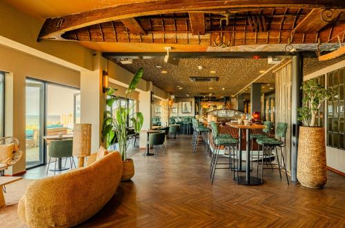a restaurant with chairs and tables in a room at Beachhouse Hotel in Zandvoort