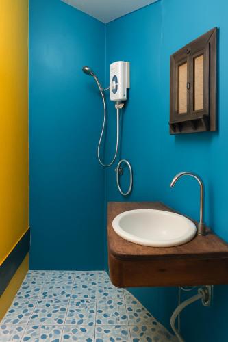 a bathroom with a sink and a blue wall at Pai Amore in Pai