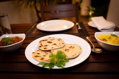 安伯朗戈德Dhyana Beach Villa的一张木桌,上面有盘子的食物