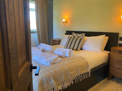 a bedroom with a bed with towels on it at Hunters Cabin - Rustic farm stay in Great Chart