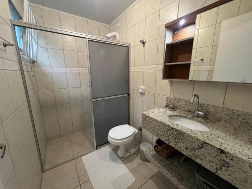 a bathroom with a shower and a toilet and a sink at Casa de 03 dormitórios no centro de Bombinhas in Bombinhas