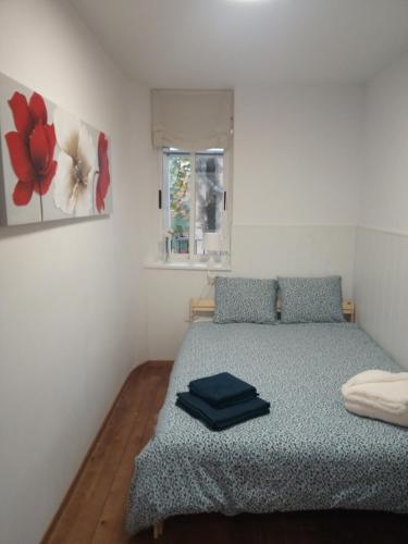 a bedroom with a bed with a blue comforter and a window at Espai One Valencia in Valencia