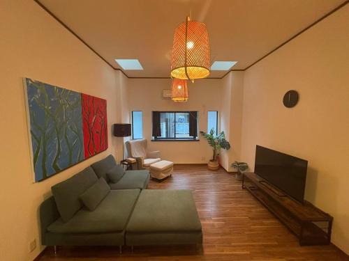 a living room with a couch and a tv at MORNING AsaHI 02 旭 in Osaka