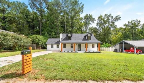 a house on a grassy yard with a yellow mailbox at The Hidden Oasis! Minutes to dwntwn and ATL airpt! in Jonesboro