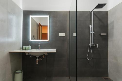 un bagno con lavandino e doccia di Kuvin Villa a Hikkaduwa
