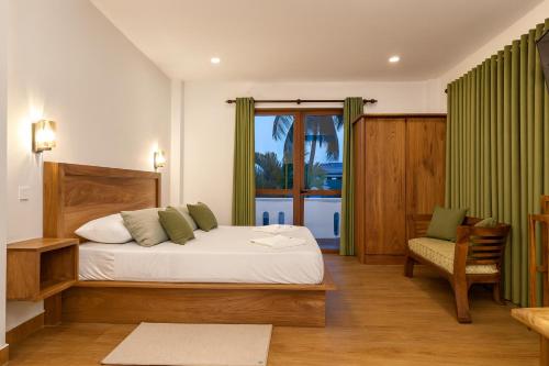 una camera da letto con un letto, una sedia e una finestra di Kuvin Villa a Hikkaduwa