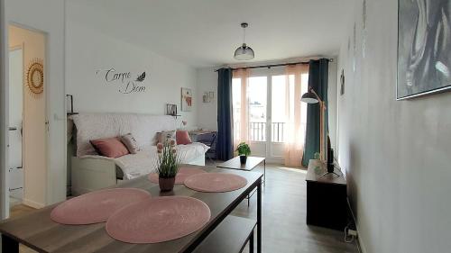 ein Wohnzimmer mit Tisch und Couch in der Unterkunft L'Eure Au Soleil, avec balcon et Wifi in Évreux