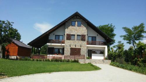 una grande casa con tetto di gambero e vialetto di Agropensiunea Ioana a Suceava