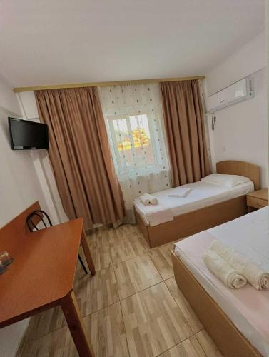 a room with two beds and a desk and a window at Sofia in Călăraşi