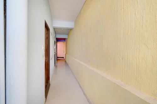 un couloir vide avec un mur blanc et une porte dans l'établissement Hotel O Stayo, à Kukatpally