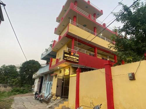 a yellow and red building with a sign on it at Hotel O Shubh Inn in Jhānsi