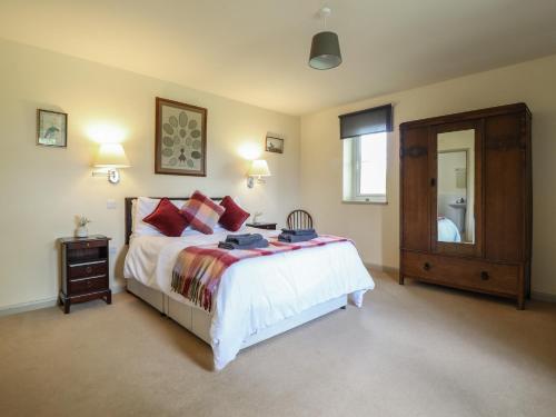 a bedroom with a bed and a dresser and a mirror at Upper Pandy Farm in Welshpool