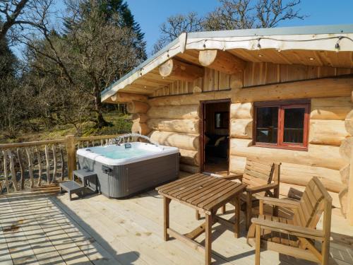 une cabine en bois avec un bain à remous sur une terrasse dans l'établissement Pine Marten, à Kilmichael Glassary