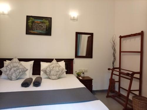 a bedroom with a bed and a chair and a mirror at Villa D40 in Weligama