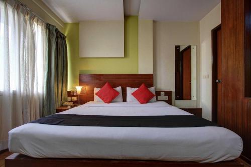 RājpurにあるHotel O namaste doonのベッドルーム1室(大型ベッド1台、赤い枕付)