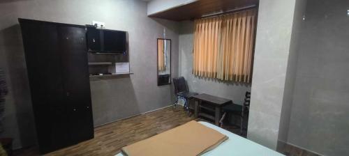 a room with a flat screen tv on the wall at Hotel O Kumar's Amantran Lodging in Manor