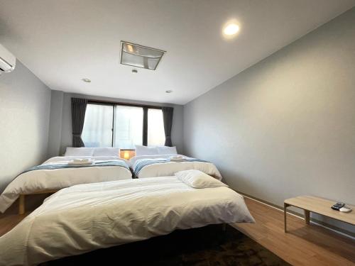 a bedroom with three beds and a window at アムホテル in Tokyo
