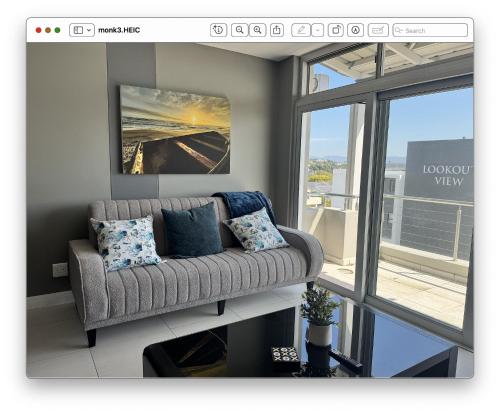 a living room with a couch in front of a window at 22 Monks View in Plettenberg Bay