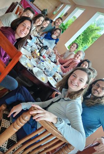 un grupo de personas sentadas alrededor de una mesa en una habitación en Pross Residence, en Masindi