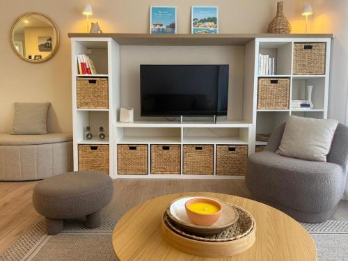 a living room with a tv and a table at T2, 50 m beach, balcony with sea view in La Teste-de-Buch