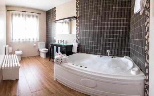a bathroom with a large tub and a toilet at Alojamientos Callejón del Pozo, cerca Puy du Fou in Gálvez