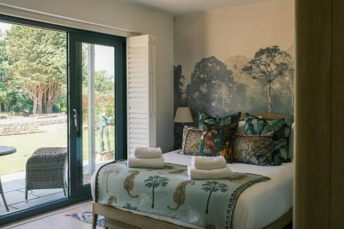 Un dormitorio con una cama y una ventana grande. en The Frogs - Cookswood, en Holcombe