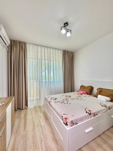 a bedroom with a bed and a large window at IN APART HOTEL in Bucharest