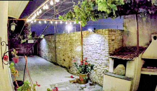 a room with a stone wall with a stone fireplace at En Sylikion cottage in Silikou