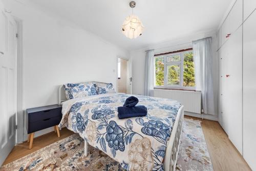 Schlafzimmer mit einem Bett mit einer blauen und weißen Bettdecke in der Unterkunft Modern spacious four bedroom house in London in Hendon