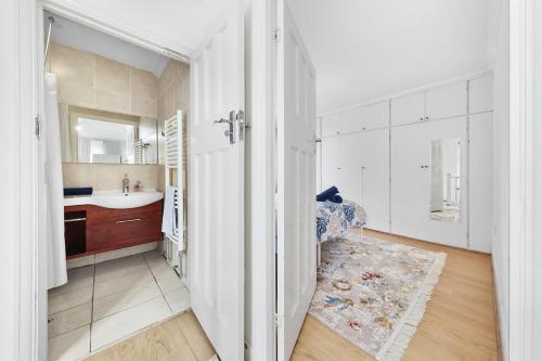 ein weißes Badezimmer mit Waschbecken und Spiegel in der Unterkunft Modern spacious four bedroom house in London in Hendon