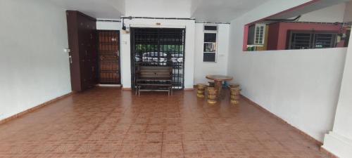 a room with a hallway with a door and a brick floor at NazAnie Homestay in Kota Tinggi