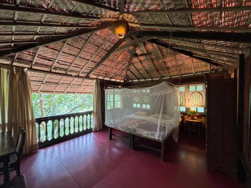 a bedroom with a bed in a room with a balcony at Khaama Kethna Eco Sustainable Village in Agonda