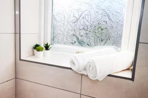 a window with a roll of paper towels in a bathroom at Entire 3-Bed Home Sheffield in Ecclesfield