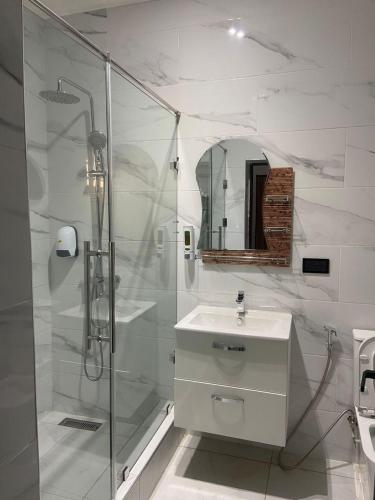 a bathroom with a shower and a toilet and a sink at Maxjen Executive Lodge in Amasaman