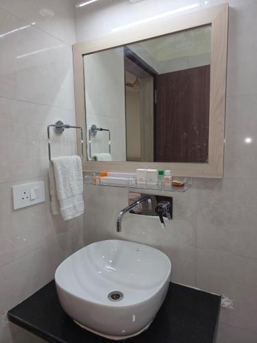 a bathroom with a white sink and a mirror at Corporate Habitat in Bhubaneshwar
