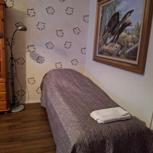 una camera da letto con un letto e un quadro sul muro di Kontiopuisto a Pieksamaki