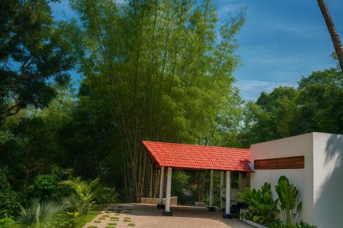 马迪凯里Hillscape Resort的花园中带红色屋顶的凉亭