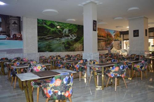 a restaurant with tables and chairs and a large mural at Maarif elite Suites in Casablanca